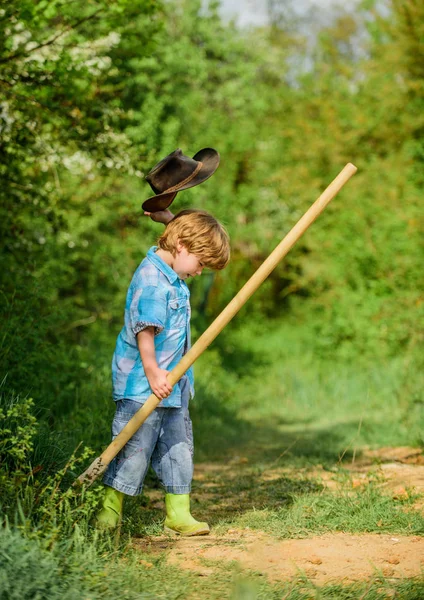 Little helper working in garden. Cute child in nature having fun with shovel. I want to find treasures. Happy childhood. Adventure hunting for treasures. Little boy with shovel looking for treasures