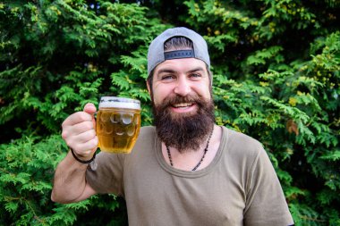Bira harika bir yaz içeceğidir. Sakallı adam yaz doğasında bira bardağı tutuyor. Acımasız hipster yaz günü ferahlatıcı bira içiyor. Mutlu içici yaz saati zevk