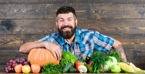 Welcome to my farm. Man bearded farmer harvest wooden background. Farmer with homegrown vegetables. Vegetables organic harvest. Farmer rustic style guy. Natural foods. Vegetarian lifestyle concept