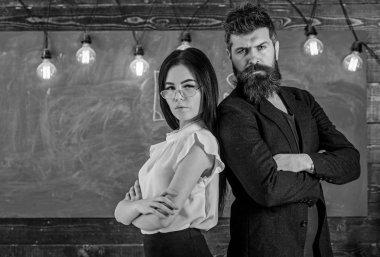 Sakal ve gözlük stand sırt sırta, kara tahta arka plan öğretmen olan adam. Öğretmen ve öğretmen rahat görünüyor. Bayan ve birlikte okulda çalışan hippi. Okul personeli kavramı