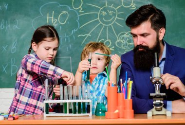 Öğretmen ve öğrenciler sınıfta test tüpleri. Çocuklar bilim gibi kulüp alanında büyüyebilir. Maddelerin özelliklerini birlikte keşfedin ve keşfedin. Kimya temalı kulüp. Okul kulübü eğitimi