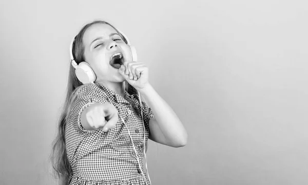 Een lied voor elke emotie. Schattig amateur Karaoke lied zanger op blauwe achtergrond. Schattig klein kind doet vocale op lied. Klein meisje zingen lied spelen in hoofdtelefoon, kopieer ruimte — Stockfoto