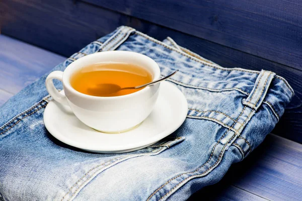 Herbal green or black whole leaf. Mug filled boiling water and tea bag on blue jeans background. Healthy habits. Tea time concept. Cup mug hot water and bag of tea. Process tea brewing in ceramic mug