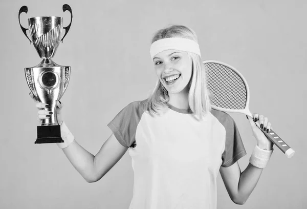 Vincere una partita di tennis. Le donne indossano abiti sportivi. Il tennista vince il campionato. Primo posto. Risultati sportivi. Festeggia la vittoria. Campione di tennis. Ragazza atletica tenere racchetta da tennis e calice d'oro — Foto Stock