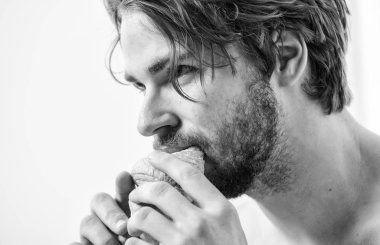 Rahatlama ve dinlenme. Yatak odası ya da otel odasında yatıyordu yatak süre tutar kruvasan ve kahve sahip adam. Yakışıklı delikanlı içki kahve ve yatakta yeme kruvasan. Sabah kahvesi.