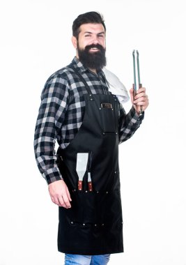 Açık havada et kavurma araçları. Piknik ve barbekü. Parkta et pişirmek. Barbekü ustası. Sakallı hipster barbekü için önlük giyer. Kavurma ve ızgara yemeği. Adam pişirme gereçleri barbekü tutun