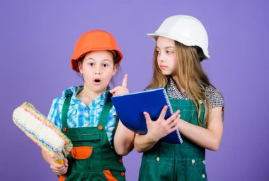 Tablet ve rulo ile kask küçük çocuklar. İşçi bayramı. 1 mayıs. küçük kızlar atölyede birlikte tamir. Foreman müfettişi. Onarım. mühendislik fikri. Benim fikrim mükemmel. Fikrimi tanıtmama izin ver.