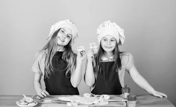 Hemgjorda cookies bäst. Barn baka kakor tillsammans. Barn förkläden och hattar matlagning. Familjerecept. Kulinarisk utbildning. Mors dag. Bakning ingefära kakor. Flickor systrar ha kul ingefära deg — Stockfoto