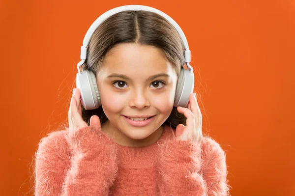 A música moderna é seu estilo de vida e prazer. Pequena menina moderna usando fones de ouvido Bluetooth. Criança pequena ouvindo música na vida cotidiana. Usando a tecnologia moderna na vida diária. Vida moderna — Fotografia de Stock