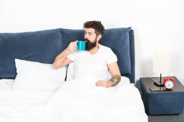 İnsanlık kahveyle çalışır. Adam acımasız yakışıklı hipster rahatlatıcı yatak odası içki kahve. Sakallı adam sabah kahvesi içiyor. Yeni güne uyum içinde. Sabah fincan kahve ile daha iyi uyanma. Rahatlayın ve dinlenin