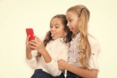 Çevrimiçi eğlence kavramı. Liseli kızlar sosyal ağları kontrol etmek için akıllı telefon kullanırlar. Mesaj gönder dostum. Çevrimiçi iletişim. Selfie sosyal ağını gönder. Komik selfie için somurtuk. Komik fotoğraflar yüklüyorum.