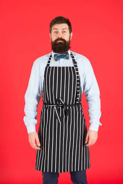 Είμαι απόλυτα στη διάθεσή σας. Ένας άντρας υπηρέτης. Ο άντρας με τα γένια φοράει ποδιά. Ο άνθρωπος μαγειρεύει με γένια και μουστάκι στην ποδιά μαγειρικής. Κομψός σερβιτόρος ή μπάρμαν — Φωτογραφία Αρχείου