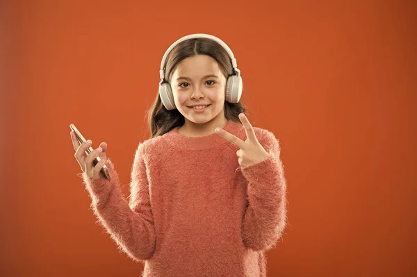 Απολαύστε μουσική αντίληψη. Καλύτερες εφαρμογές μουσικής που αξίζει να ακούσετε. Κορίτσι παιδί ακούει μουσική μοντέρνα ακουστικά και smartphone. Ακούστε δωρεάν. Αποκτήστε μουσική οικογενειακή συνδρομή. Πρόσβαση σε εκατομμύρια τραγούδια — Φωτογραφία Αρχείου