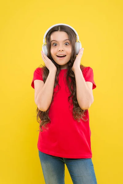 Αντιμετώπισε τον ήχο. Αξιολάτρευτο κοριτσάκι ακούγοντας ήχο σε κίτρινο φόντο. Χαριτωμένο μικρό παιδί που φοράει ακουστικά παίζοντας ηλεκτρονικό ήχο. Χαλαρωτικό με μελωδικό ήχο — Φωτογραφία Αρχείου