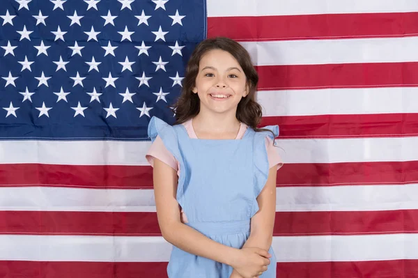 Libre né et élevé librement. Petit enfant insouciant jouissant d'une enfance heureuse. Bonne petite fille souriant sur le décor du drapeau américain. Le libre développement. La libre expression de la volonté — Photo