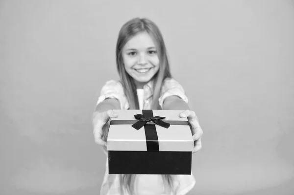 Questo è per te. Un piccolo regalo da shopaholic avvolto in una scatola. Bambino piccolo con confezione regalo legata con fiocco a nastro. Carino shopper piace fare un po 'di shopping. Piccola ragazza dopo lo shopping per il regalo — Foto Stock