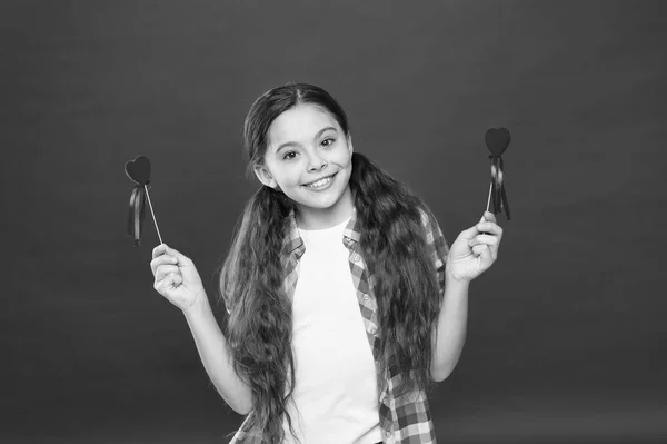 Flicka söt barn med hjärtan. Kid flicka med långa hår röd bakgrund. Fira Alla hjärtans dag. Mödrar dag semester. Tradition fira alla hjärtans dag. Uppriktig kärlek. Bli min valentine. Familj älskar — Stockfoto