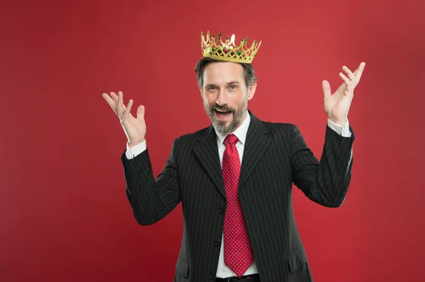 Su sueño de ser campeón se hizo realidad. Campeón coronado sonriendo con corona sobre fondo rojo. Feliz hombre de negocios disfrutando de título de campeón. Exitoso campeón del proyecto o ganador después de la coronación — Foto de Stock