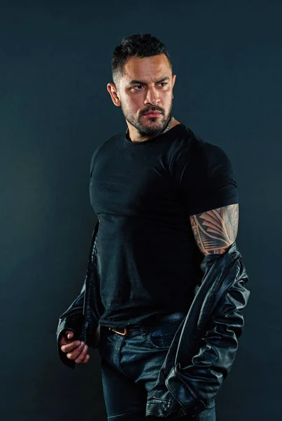 Güçlü kol adam Haritayı dövme sakallı. Dövmeli adam tshirt ve deri ceketli. Moda maço tıraşsız yüzündeki sakallı. Erkeklik ve güç. Moda stil ve eğilim