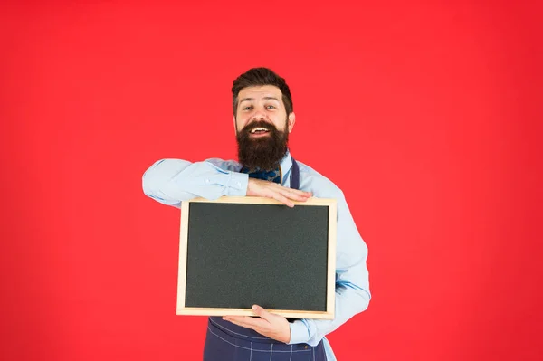 Open hours. Hipster bartender show blackboard copy space. Hipster restaurant staff. Hipster informing you. Man bearded bartender or cook in apron hold blank chalkboard. Schedule and timing concept