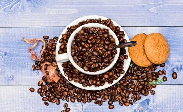 Concepto de cafeína. Café bebidas menú. Arabica robusta variedad de café. Bebida para la inspiración y la carga de energía. Copa café completo marrón frijol asado fondo de madera azul. Granos de café tostados frescos —  Fotos de Stock