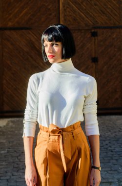 Yüksek belli. Kadınlık ve kadınsı rakam vurgulamak. Kız makyaj yüz gevşek yüksek bel pantolon giymek. Yüksek belli pantolonlar podyuma dönmeye devam ediyor. Kadın çekici esmer şık kıyafeti