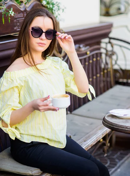 Breakfast time in cafe. Girl enjoy morning coffee. Woman in sunglasses drink coffee outdoors. Girl relax in cafe cappuccino cup. Caffeine dose. Coffee for energetic successful day. Waiting for date