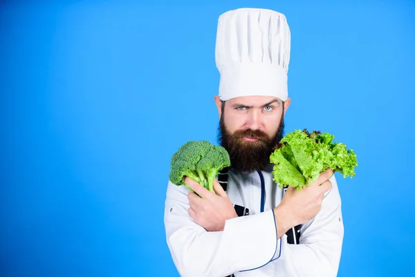 Vitamin. Der Mensch benutzt Geschirr. Profi-Koch in Uniform. gesunde Kost und vegetarisch. Ein ernsthafter Mann kocht in der Küche. Ernährung mit Biolebensmitteln. frisches Gemüse. Gesundheit in seinen Händen. Kopierraum — Stockfoto