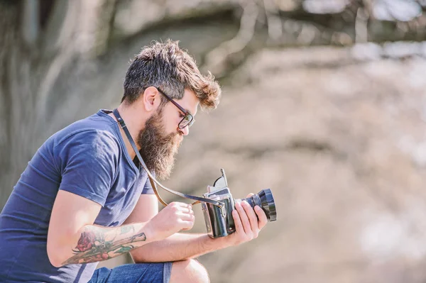 outdoor photographic equipment. hipster man in sunglasses. brutal photographer with camera. Mature hipster with beard. Bearded man. photo of nature. reporter or journalist. Enjoying his working day