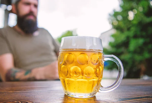 Man sit cafe terrace enjoying beer defocused. Alcohol and bar concept. Creative young brewer. Craft beer is young, urban and fashionable. Distinct beer culture. Mug cold fresh beer on table close up — Stock Photo, Image