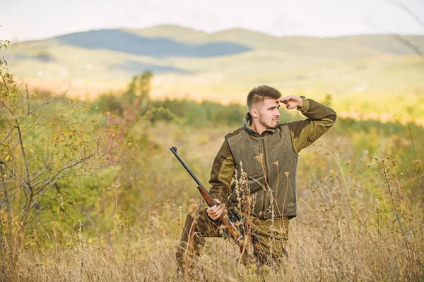 Bearded hunter spend leisure hunting. Hunter hold rifle. Focus and concentration of experienced hunter. Hunting and trapping seasons. Man brutal gamekeeper nature background. Hunting permit