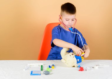 çocuk doktoru stajyeri. Tıbbi üniformalı küçük çocuk. stetoskoplu çocuk doktor. Tedavi reçetesi. hemşire laboratuvar asistanı. Aile doktoru. Hastane. tıp ve sağlık. küçük çocuk stajyer