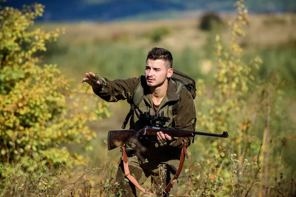 Hunter tüfeği tutuyor. Adam kamuflaj giysileri doğa arka plan giymek. Avlanma izni. Profesyoneller için av ekipmanları. Avlanmak acımasız erkeksi bir hobidir. Sakallı ciddi avcı boş zaman avcılık harcamak — Stok fotoğraf