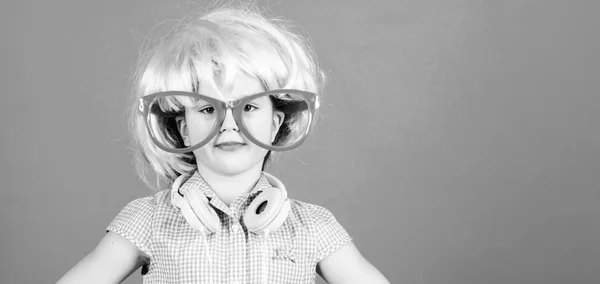 Synthetic hair. Cool little child with pink hair wig. Adorable small girl with fancy hair style wearing headphones. Beauty look of crazy hair model, copy space — Stock Photo, Image