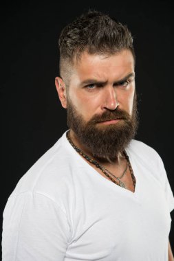 Saç tasarım trendleri. Siyah arka plan üzerinde uzun sakallı ve şık saçlı ciddi hipster. Traşsız surat kıllı sakallı adam. Şekilli sakallı ve bıyıklı saçlı acımasız adam