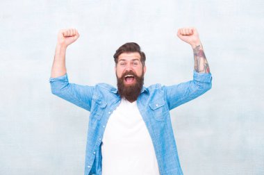 Mutluluk ve neşe. Sakallı ve bıyıklı hipster mutlu ifade. Gri duvar arka plan üzerinde Acımasız yakışıklı hipster adam. Kutlama konsepti. Sakallı adam moda hipster tarzı. Neşeli ruh hali