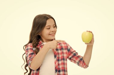 Çocuk gülen surat elma gibi. Okul yemeği konsepti. Sağlıklı beslenme diyeti. Elma vitamini atıştırması. Şirin, uzun kıvırcık saçlı bir kız, beyaz elma arkaplanı tutuyor. Çocuk kıyafetleri elma tutar.