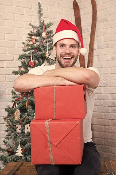 Homem Papai Noel sorriso com caixas na árvore de Natal — Fotografia de Stock