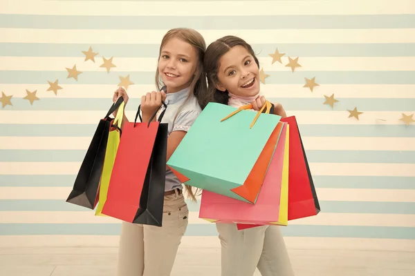 Boldog gyerekek csomó csomagok szállítására. Vásárlás a legjobb barát koncepció. Lányok, mint a vásárlás. Gyerekek boldog kis lány bevásárló táska tartsuk. Élvezze a vásárlás a legjobb barátja és a nővére. Kislányos boldogság — Stock Fotó