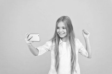 Video yayını. Sevimli çocuk yeni teknoloji öğreniyor. Cep telefonu kullanan küçük bir kız. Akıllı telefonu olan küçük bir kız çocuğu. Güzel cep telefonu teknolojisi kullanıcısı. Mobil aygıtta video izleniyor