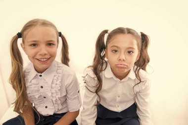 Uzun saçlı kızlar beyaz arka planda at kuyruğu yaparlar. Liseli kızlar sevimli arkadaşlar. Saç bakımı ve tedavi. Uzun saç tedavisi. Uzun, sağlıklı saçların nasıl uzadığını. Çocukluk arkadaşlığı. Öğrenci üniformaları düzenli.