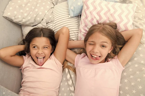 Slumber party timeless childhood tradition. Girls relaxing on bed. Slumber party concept. Girls just want to have fun. Invite friend for sleepover. Best friends forever. Consider theme slumber party