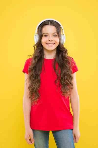 La única música que importa. Adorable chica disfrutando de la música sobre fondo amarillo. Niño pequeño escuchando música en auriculares estéreo. Educación musical para niños pequeños — Foto de Stock