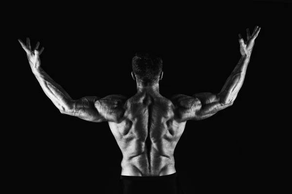 彼は筋肉の為だ。筋肉質の男のバックビュー。筋肉力を示すフィットアスリート。筋肉を持つ強いスポーツマンは腕を上げる。ヘス筋肉と運動, 黒と白 — ストック写真