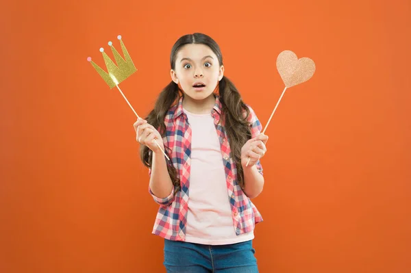 With no expectation of reward. Little girl holding prop crown and heart on stick as favorite reward. Cute mini miss beauty pageant winner enjoying reward for success. Awarding with prize and reward — Stock Photo, Image