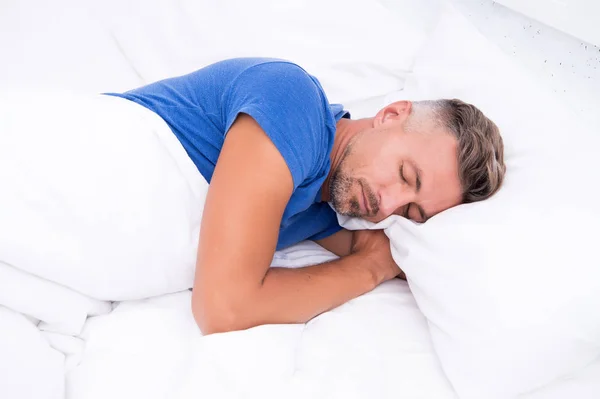 Bella durmiente. Un hombre guapo yacía en la cama. Duerme lo suficiente cada noche. Consejos para dormir mejor. Hombre barbudo durmiendo cara relajante en la almohada. Agradable concepto de relajación. Descanso perfecto — Foto de Stock