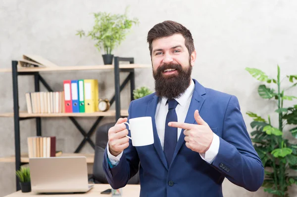 Hombre barbudo hombre de negocios celebrar café taza stand fondo de la oficina. La gente exitosa bebe café. Beber café relajante descanso. Jefe disfrutando de la bebida energética. Adicta a la cafeína. Comience el día con café — Foto de Stock