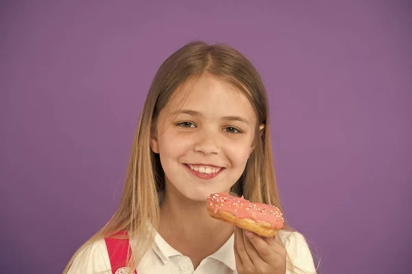 Como as crianças domesticam o dente doce. O miúdo foi recompensado pelo bom comportamento com guloseimas açucaradas. Menina bonito rosto sorridente detém doce donut. A rapariga gosta de doces como donuts. Evite recompensas com açúcar — Fotografia de Stock