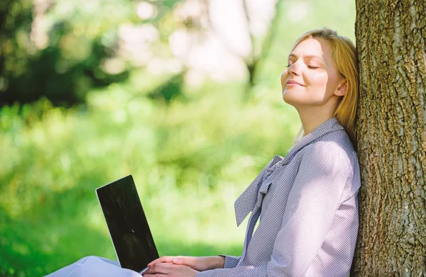 Girl work with laptop in park sit on grass. Natural environment office. Work outdoors benefits. Woman with laptop work outdoors lean tree. Minute for relax. Education technology and internet concept — Stock Photo, Image