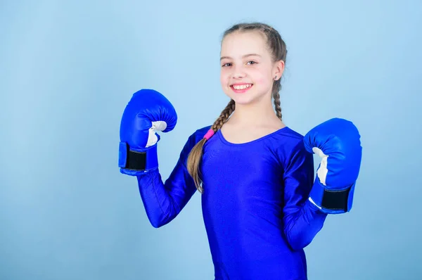 Girl cute boxer on blue background. Rise of women boxers. Female boxer change attitudes within sport. Feminism concept. With great power comes great responsibility. Boxer child in boxing gloves